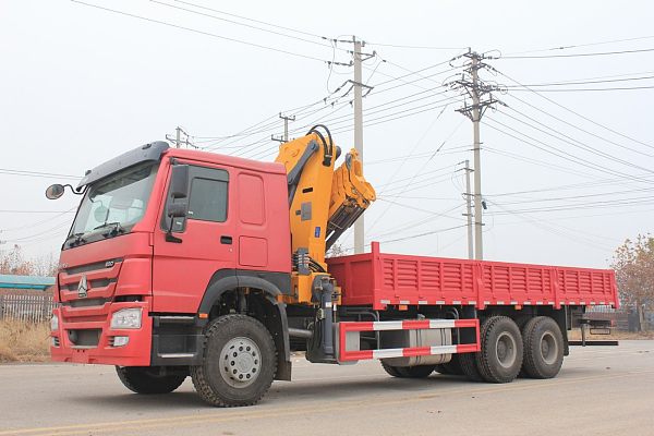 Grue à bras repliable montée sur camion-caisse à plateau